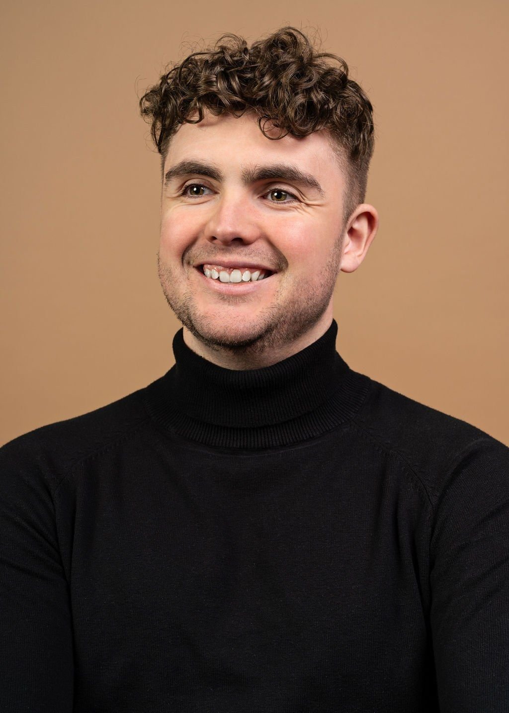 Headshot: smiling, black turtleneck